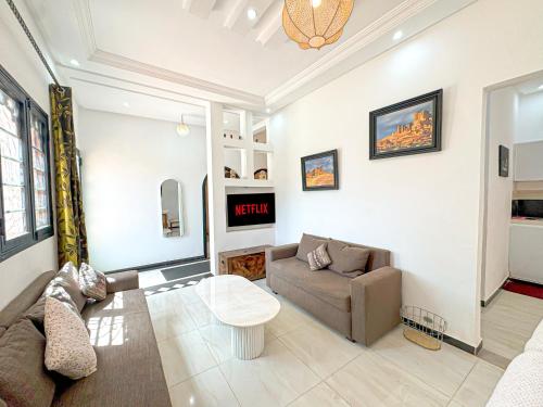 a living room with a couch and a table at Évasion Douce avec jardin, terrasse et piscine privée in El Aggada