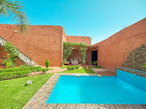 a swimming pool in the yard of a house at Évasion Douce avec jardin, terrasse et piscine privée in El Aggada