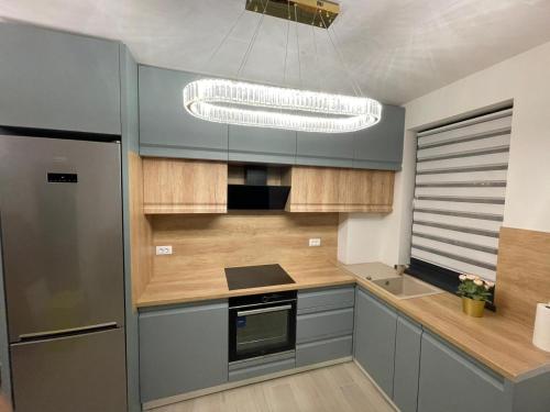 a kitchen with blue cabinets and a chandelier at Urban Residence in Poiana Brasov