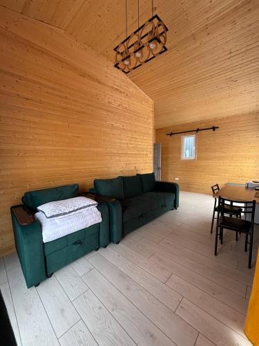 a living room with a green couch and a table at Jargylchak-Sunrise in Kichi-Jargylchak