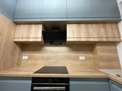 a kitchen with wooden cabinets and a black stove at Urban Residence in Poiana Brasov