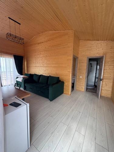 a living room with a green couch and a refrigerator at Jargylchak-Sunrise in Kichi-Jargylchak