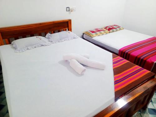 two beds sitting next to each other in a room at Deer Garden Guest in Polonnaruwa