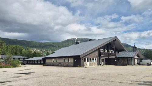 a large building with a mountain in the background at Cozy apartment with pool in Bjorli