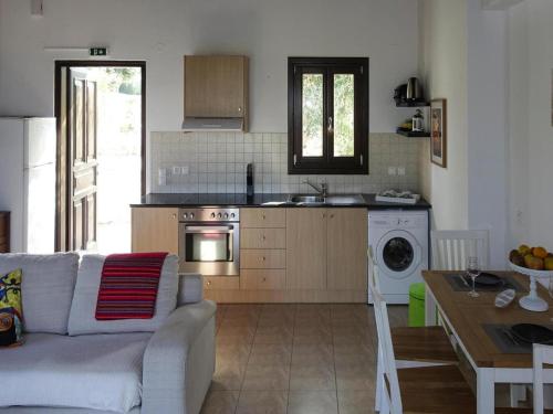 a living room with a couch and a kitchen at Cottage, Kyrianna in Kiriánna