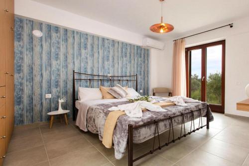 a bedroom with a bed with a blue wall at Cottage, Kyrianna in Kiriánna