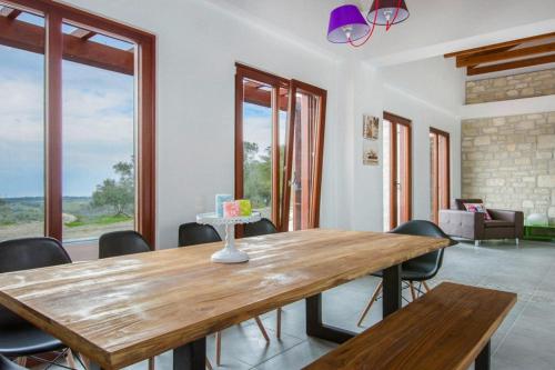 a dining room with a wooden table and chairs at Cottage, Kyrianna in Kiriánna