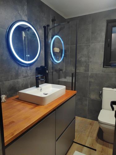baño con lavabo blanco y 2 espejos en Panorama retreat, en Oradea