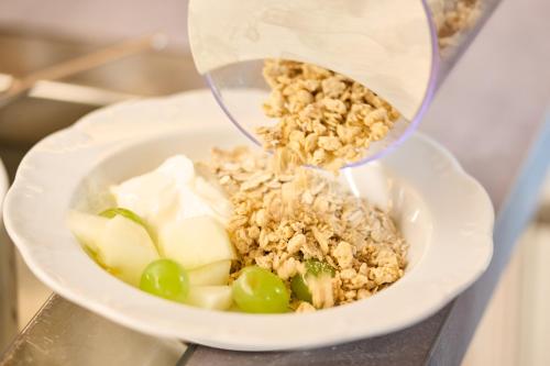 a bowl of food is being poured into a bowl of food at Hotel Heidehof garni in Büdelsdorf