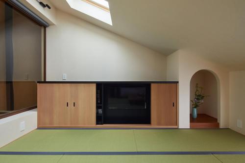 a living room with a flat screen tv on a wall at Enso Machiya in Kyoto