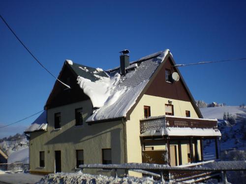 a house with snow on the roof of it at Cozy Ski Base with Garden in Breitenbrunn