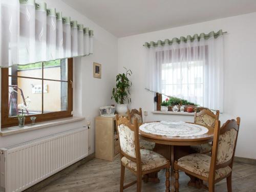 a dining room with a table and chairs and a window at Cozy Ski Base with Garden in Breitenbrunn