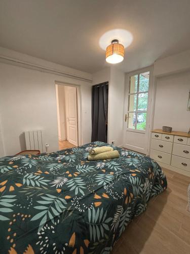 a bedroom with a bed with a green and orange blanket at Les Châtaigniers in Villeneuvette