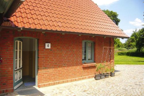 a small brick building with an orange roof at Holiday home, Plau am See in Plau am See