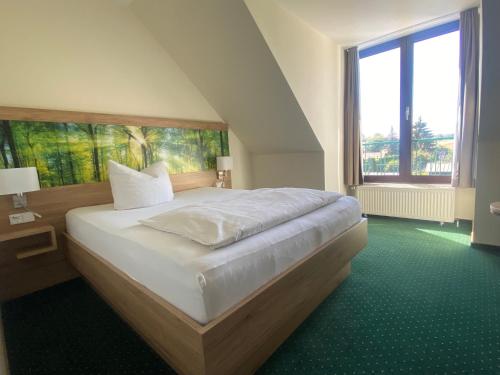 a bedroom with a bed and a large window at Hotel Schwartze in Weimar