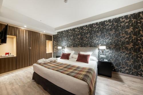 a bedroom with a large bed and a wall at Castilla Termal Burgo de Osma in El Burgo de Osma