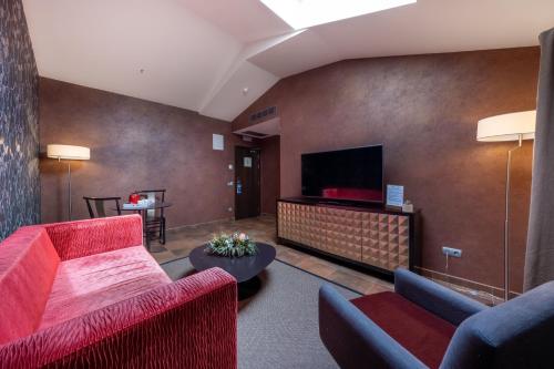 a living room with red furniture and a flat screen tv at Castilla Termal Burgo de Osma in El Burgo de Osma