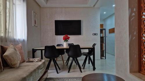 a living room with a table and a couch at Appart familial, fibre50 mbps parking,ipptv in Kenitra