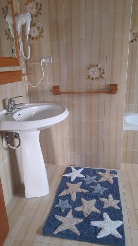 a bathroom with a sink and a blue rug at Belvedere Experience Apartment in Caprioli