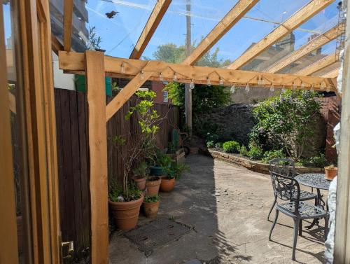 a patio with a wooden pergola and a table and chairs at Compton House, Llanfyllin in Llanfyllin