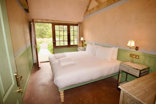 a bedroom with a white bed and a window at West Lexham Retreat in Kings Lynn