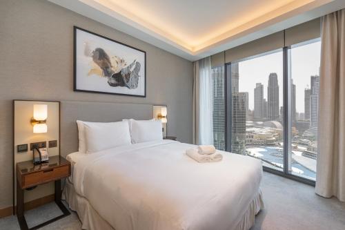 a bedroom with a large white bed and a large window at Shukr شكر - Luxury 3BR with Panoramic Burj Khalifa & Fountain Views - Address Residence Dubai Opera - 2 Min Walk to Dubai Mall in Dubai