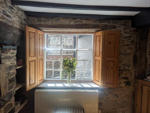 a window with a vase sitting in a window sill at Compton House, Llanfyllin in Llanfyllin