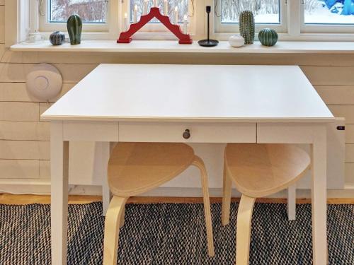 a white desk with two chairs in a room at 4 person holiday home in GRISSLEHAMN-By Traum in Grisslehamn