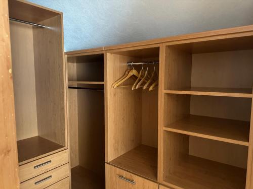 a closet with wooden shelves and hangers at Villa Racing - Privatzimmer in Spielberg in Spielberg