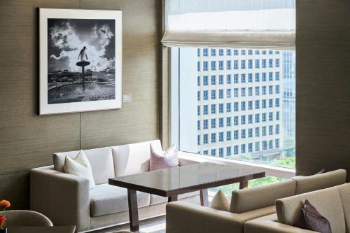a living room with a table and chairs and a window at Le Meridien Taipei in Taipei