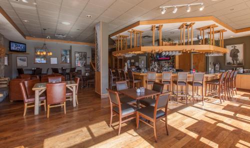 a restaurant with tables and chairs and a bar at Coast Hillcrest Hotel in Revelstoke