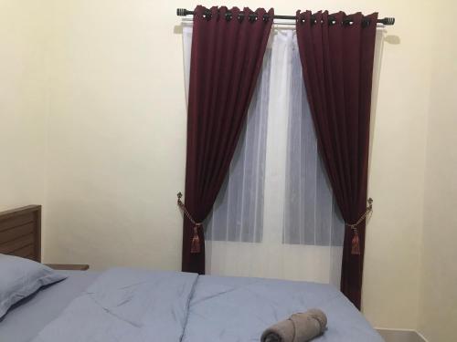 a bedroom with a bed with red curtains at Lahar Villa Lombok in Masbagik