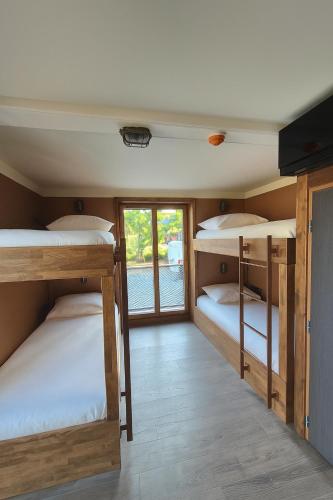 a room with four bunk beds and a window at La Tour de Contrôle - Chambres & Appartements in Challes-les-Eaux