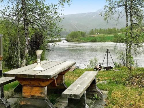 a wooden table with a vase on it next to a river at 6 person holiday home in Ballangen in Ballangen