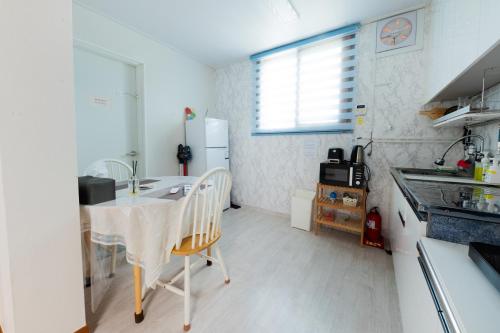 a small kitchen with a table and a refrigerator at Tov Stay Atti in Pyeongtaek