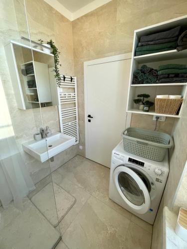 a bathroom with a washing machine and a sink at Mirno in elegantno stanovanje - Parkirišče, Netflix, wifi in Maribor