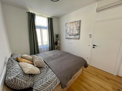 a bedroom with a bed with pillows on it at Mirno in elegantno stanovanje - Parkirišče, Netflix, wifi in Maribor
