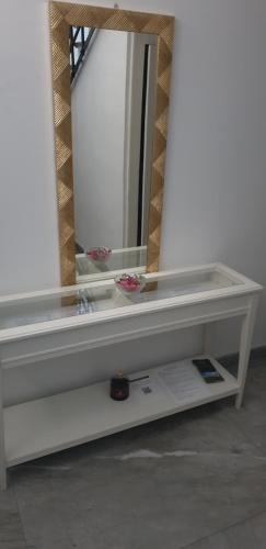 a mirror on top of a white shelf in a room at Lyberty in Randazzo