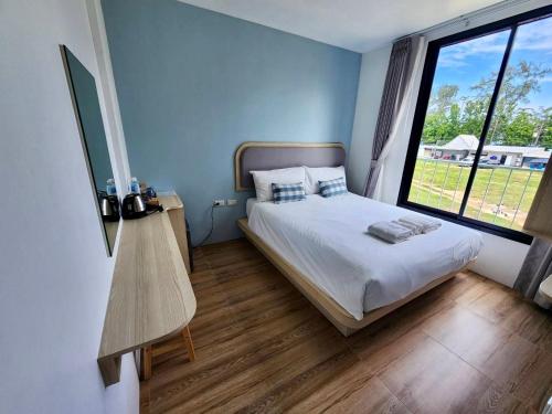 a bedroom with a bed and a large window at Sea Side at Ao Nang Landmark Night Market Krabi in Ban Khlong Haeng