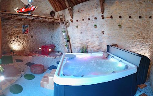 Una bañera grande en una habitación con un coche de juguete. en La Chaume de Condé, en La Celle-Condé