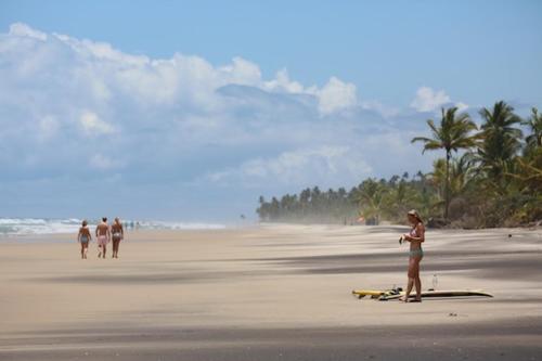 a group of people walking on a beach at Barracuda Boutique in Itacaré