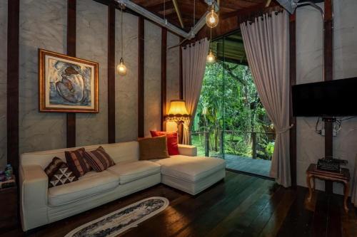 清迈Voraman B-One的客厅里有一张白色的沙发和一扇大窗户