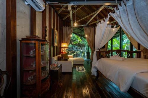a bedroom with a bed and a couch in a room at Voraman B-One in Chiang Mai