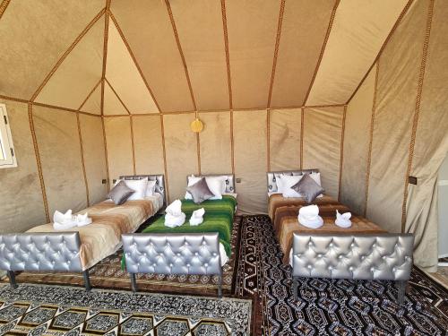 a room with two beds in a tent at Luxury Desert Queen Camp in Merzouga
