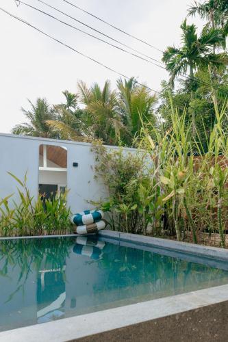 a swimming pool next to a white building with trees at 3 Bed Private Villa With Pool, 250m To The Beach in Ahangama