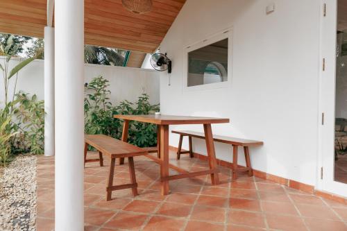 a wooden table and benches on a patio at 3 Bed Private Villa With Pool, 250m To The Beach in Ahangama