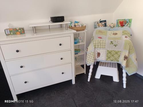 a bedroom with a white dresser and a bed and a chair at Ferienhaus Familie Zimmermann in Keutschach am See