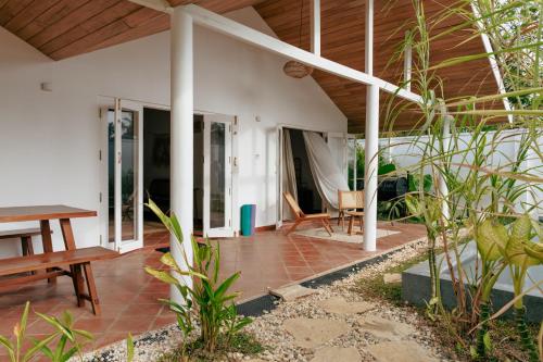 an outdoor patio with a table and a wooden ceiling at 3 Bed Private Villa With Pool, 250m To The Beach in Ahangama