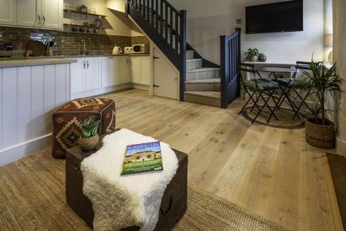 a living room with a kitchen and a staircase at The Mitre Inn in Glastonbury