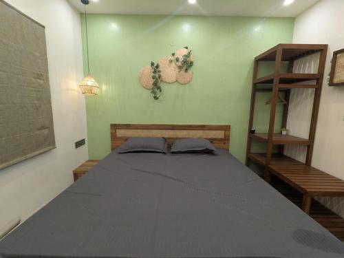 a bedroom with a bed and a green wall at Poolside Farm Retreat wit Garden in Hosūr